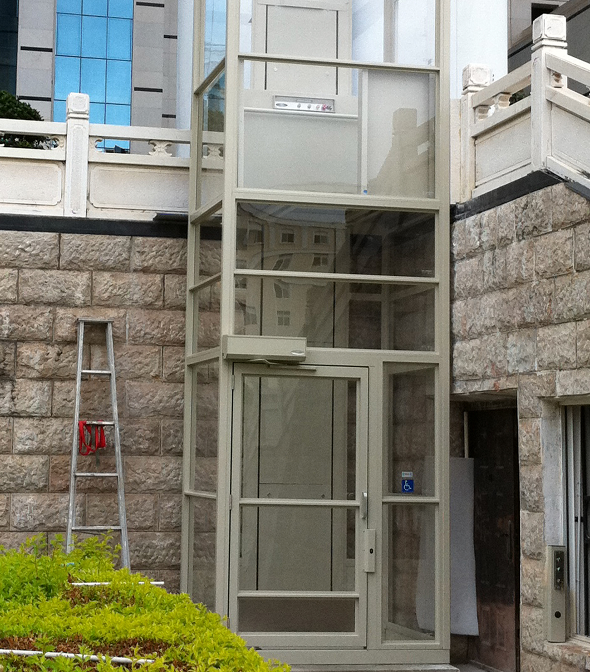 Vertical platform lift with full enclosure installed outside on a porch