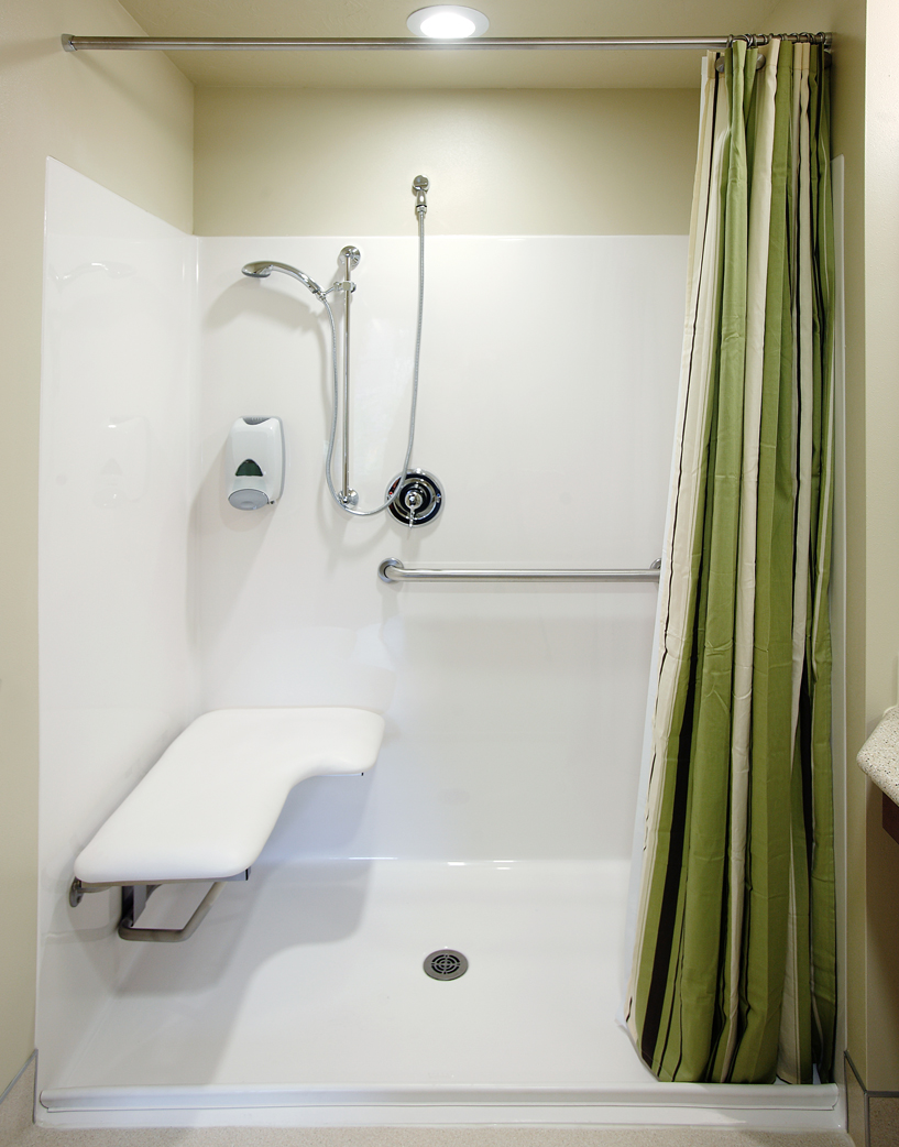 Roll-in shower tips shows small lip to prevent water overflow, grab bar and flip up bench