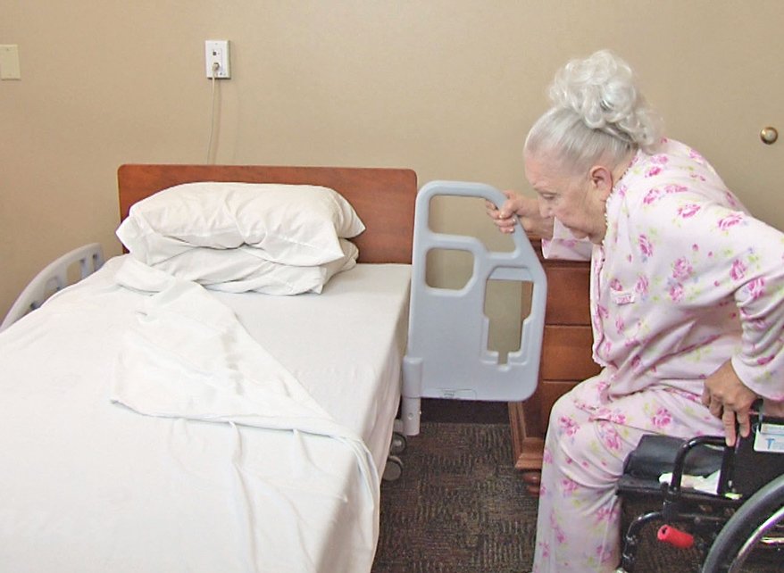 Medical bed side rail in use to assist person to stand up